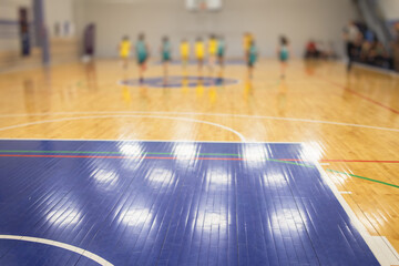 View of basketball court hall indoor venue with junior teenage school team playing in the background, basketball match game on arena stadium, team is blurred with copy space