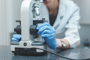 Woman scientist researching with microscope in laboratory