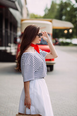 A photo of a perky beauty on the background of a red food truck with coff