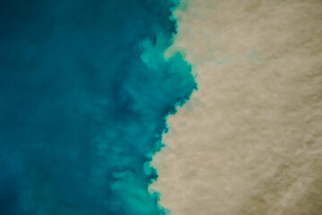 Aerial view of mixing blue and dirty ocean water. Natural background