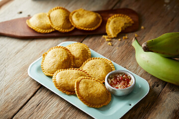 Ecuadorian empanadas de verde served on typical and wooden plates with a rustic and traditional atmosphere - obrazy, fototapety, plakaty