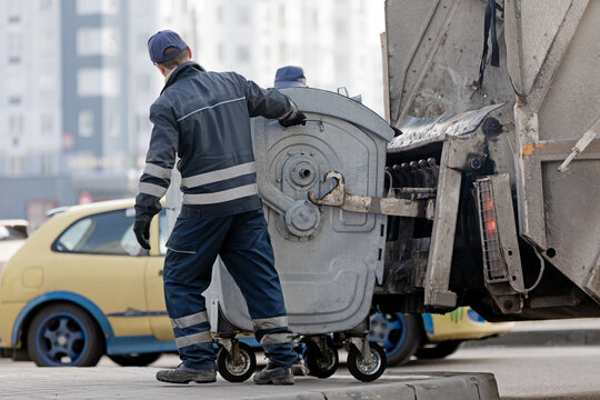 Residential Trash & Garbage Service. Workers Municipal Recycling Garbage Collector during Emptying Bin