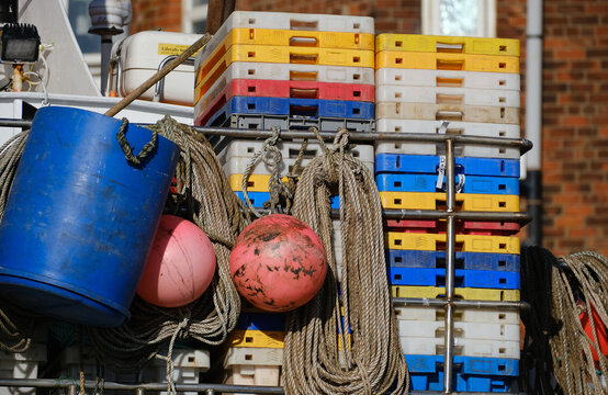 Plastic boxes and floats on back of sea fishing vessel.