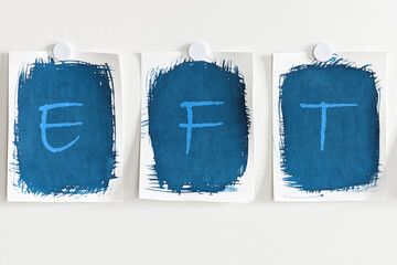 Letters EFT written on blue paper on white board. Emotional Freedom Technique concept.