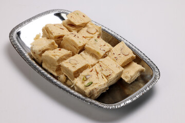 Shompapri Soan papdi cube cut flaky sweet made from flower ghee sugar on silver metal tray plate