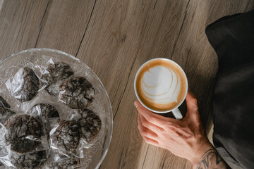 top view of coffee in a cup, chocolate biscuits lie nearby