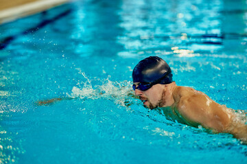 Professional male swimmer inside swimming pool.