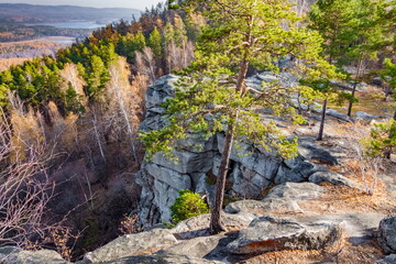 Obraz premium Autumn landscape with trees and rocks on top of a mountain against the background of lakes and forests
