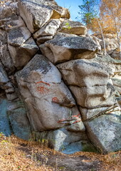 Autumn landscape with trees and rocks on top of a mountain against the sky