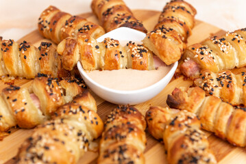 salty sticks of puff pastry sprinkled with sesame on a wooden background