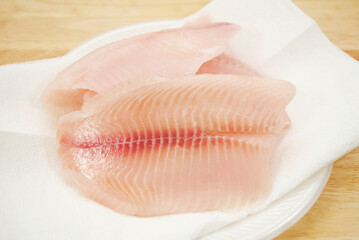 Raw Mild White Fish Drying on White Paper Towel
