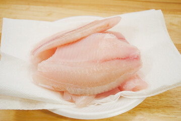 Raw Mild White Fish Drying on White Paper Towel