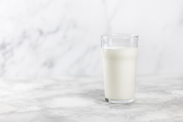 A glass of kefir on a concrete table with a bridge for copying..