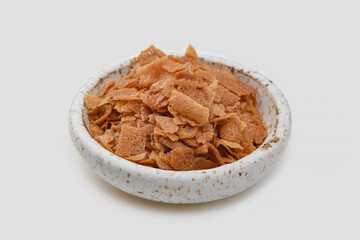 Heap of wafer or waffle crumb in a bowl on a white background.