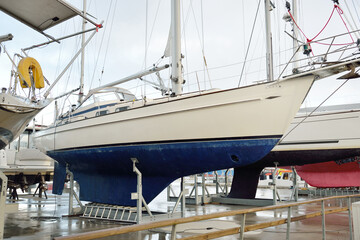 Sailboats standing on land in a yacht club. Service, repair, transportation, sport, recreation,...