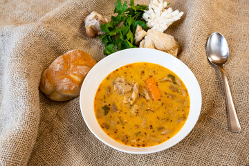 Healthy oyster mushroom soup on jute background.