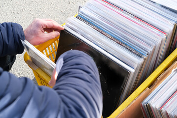 flea market flip in the city, man choosing vinyl records, antiques, old furniture, tables, used...
