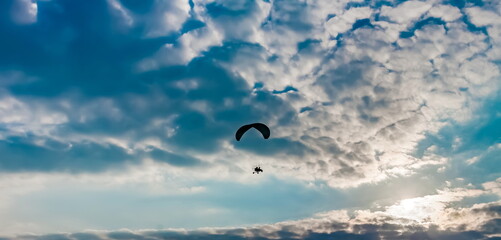 Paraglider on the background of a sunset sky with clouds in summer