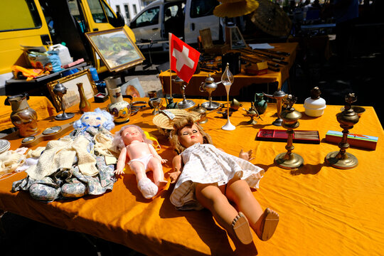 GENEVA, Switzerland - August 2021: flea market flip in city, dolls, children's toys, antiques, old furniture, used things, clothes and other goods are sold on street, recycling of unwanted items