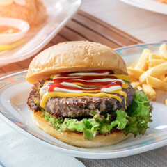 delicious hamburger with a cutlet on the table outdoor fast food real life lifestyle close-up. Breakfast in the fresh air under the sun. delicious lunch, hearty and nutritious but harmful