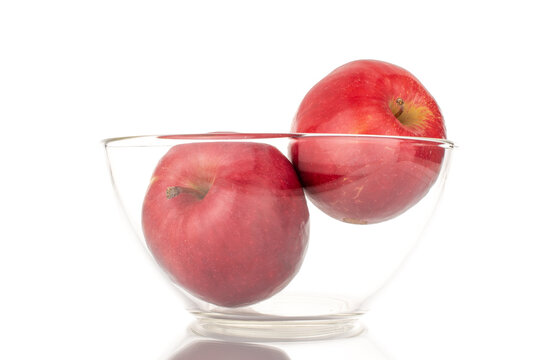 Two juicy, ripe, red apples in glassware, macro, isolated on a white background.
