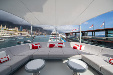 The front deck of huge yacht in port of Monaco at sunny day, landmarks of Monte-Carlo and a lot of...