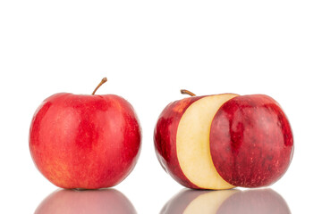 One whole and one with a cut off piece of juicy, organic, red apples, macro, isolated on a white background.
