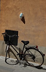 Italy. Bicycle and mask hanging on the wall.