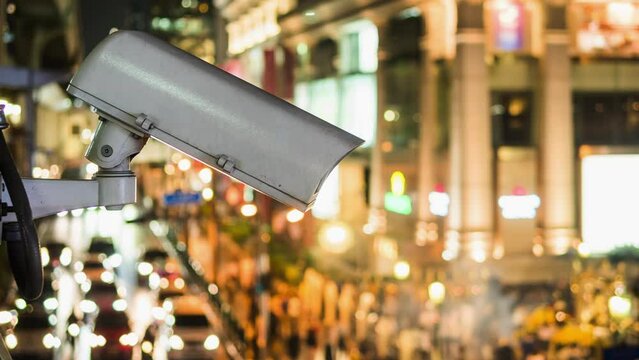 Time lapse view of surveillance camera overlooking busy intersection at night in Bangkok, Thailand, zoom out. 