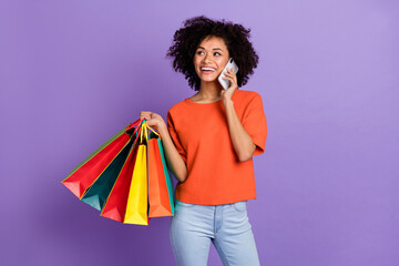 Photo of cute brown haired girl talking on phone visit shopping mall purchase clothes isolated on violet color background