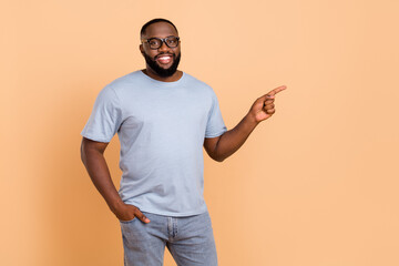 Photo of impressed young beard guy index promo wear eyewear blue outfit isolated on beige color...