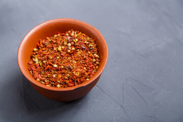 Spices in a brown bowl on a gray background. save a place.