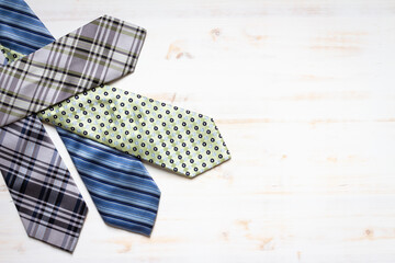 Four neck ties on a white wood background with copy space
