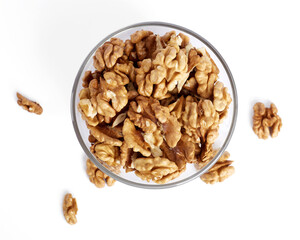 Peeled walnuts in a glass bowl top view. Isolated on white background