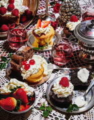 Muffin and plumcake with cream still life in posh silverware plate dishes and forks