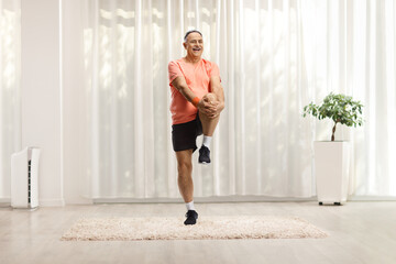 Mature man in sportswear stretching his leg and smiling