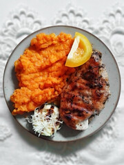 Grilled chicken steak with carrot puree, zucchini ingredients with cheese and yellow paprika. The main course of lunch or dinner is set on a ceramic plate. Enjoy your meal.