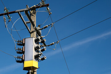 Electricity transmission pole with blue sky in the background. Electric power supply crisis