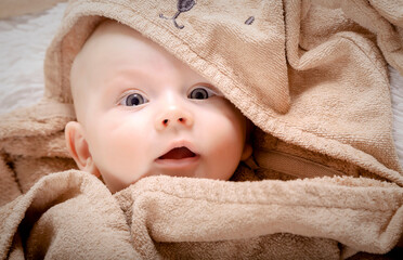 Portrait of charming baby boy in the bed after bath.