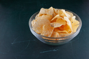 A bowl of chips over a green wood table