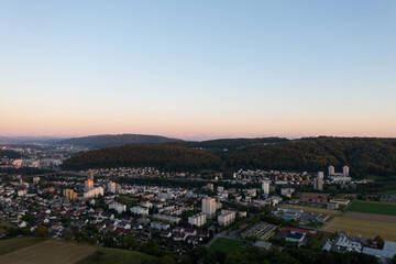 Fototapeta na wymiar Amazing shot of a beautiful landscape in the alps of Switzerland. Wonderful flight with a drone over an amazing landscape in the canton of Aargau. Epic view at sunset over a village called Nussbaumen.