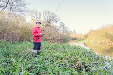Angler athlete casts spinning rod into the river.