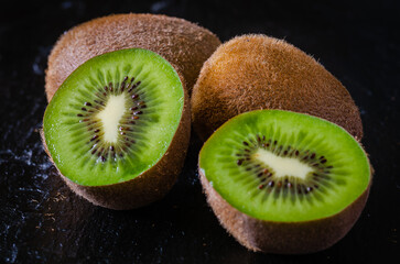 Kiwi partido a la mitad en un fonde negro. Fruta fresca saludable