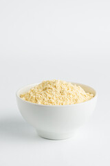 Chickpea flour  or soy flour in white bowl on white background, top view