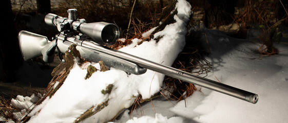 Black polymer bolt action rifle and scope with snow