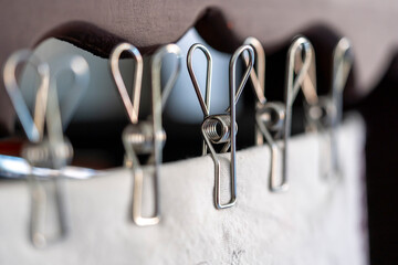 varias Pinzas de metal  bonitas con desenfoque, sosteniendo tela blanca