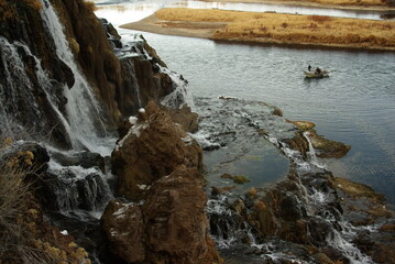 Falls above river with fisherman in drift boat