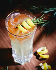 cold alcohol cocktail long drink with lemon and rosemary