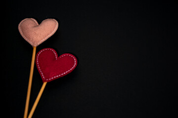 felt hearts on a stick, in burgundy and rose colors, on a black background