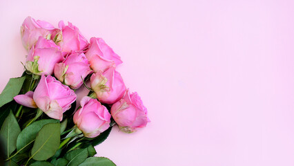 Top view, a bouquet of pink roses on a light pink background. Celebration atmosphere. Greeting card...